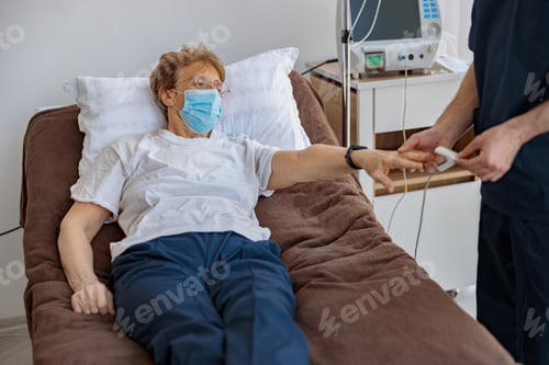 Preview: Nurse checking with fingertip pulse oximeter oxygen saturation of patient blood in hospital