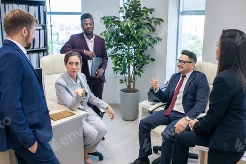Preview: Group of intercultural colleagues having discussion in office