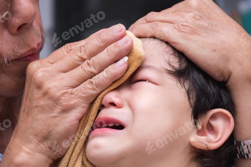 Preview: Close up of a 1-2 year old Asian face boy is crying from pain in his forehead.