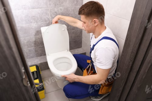Preview: Plumber flushing toilet after repairing it indoors