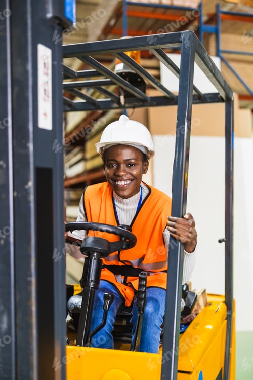 Preview: Woman forklift driver smiling in warehouse logistics