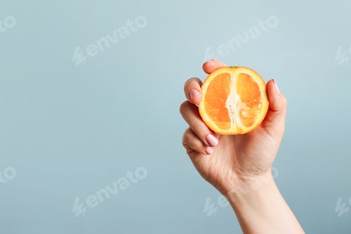 Preview: Hand Holding a Fresh Orange Slice