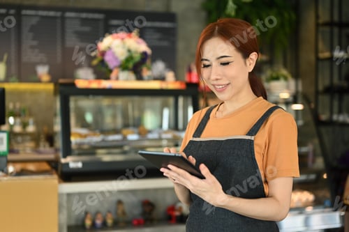 Preview: Beautiful asian woman small business owner using digital tablet, standing in cafe indoor.
