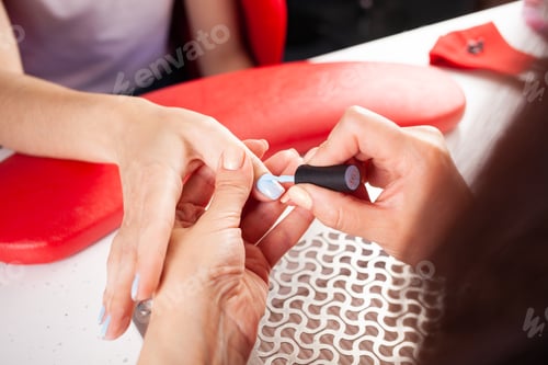 Preview: Woman Getting Manicure with Light Blue Nail Polish