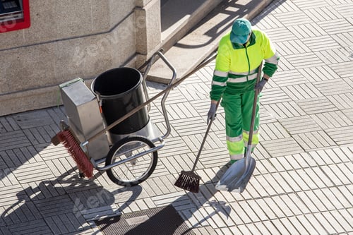 Preview: Street sweeper working on a sidewalk with her shovel, trolley and broom