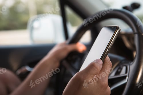 Preview: The driver's hand behind the wheel holds a smartphone. Navigator, satellite navigation