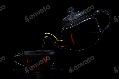Preview: Transparent teapot with black tea on a black background