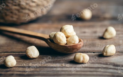 Preview: Peeled hazelnuts in a wooden spoon, close-up.
