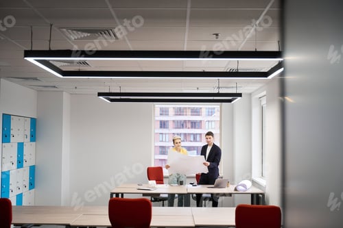 Preview: Young designers studying building blueprint in the office