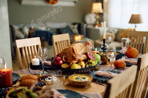 Preview: Roasted turkey for Thanksgiving meal on dining table at home.