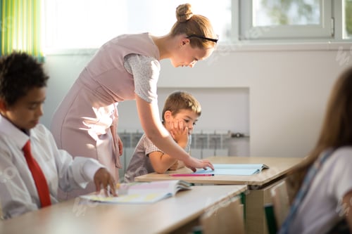 Preview: Teacher helping kids with their homework in classroom at school