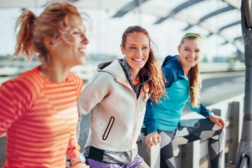 Preview: Portrait of three female runners on city footbridge
