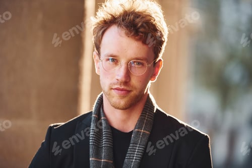 Preview: Portrait of elegant young man in glasses and formal classy clothes outdoors in the city