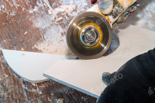 Preview: Worker cutting tile using grinder cut into layers of ceramic floor tiles