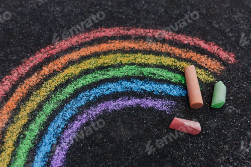 Preview: Close-up of a rainbow painted on a road with sidewalk chalk, shot from above