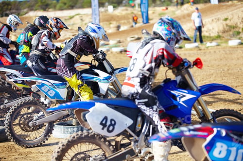 Preview: Its a race to the finish. Rear view of a group of motocross riders waiting for a race to start.