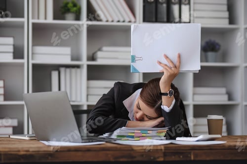 Preview: Asian businesswoman who is exhausted from work sleeping on the desk in the office.
