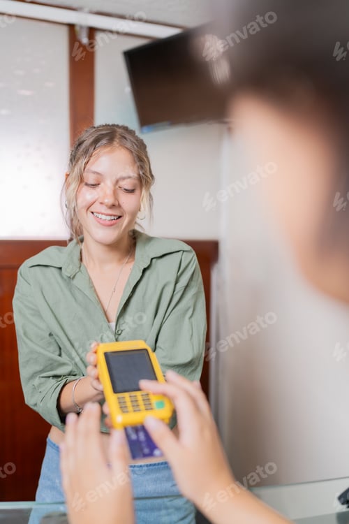 Preview: Woman using credit card to pay in a clinic