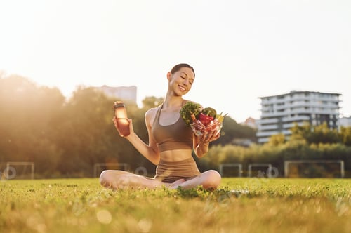 Preview: Diet conception. Healthy food. Young woman in yoga clothes is outdoors on the field