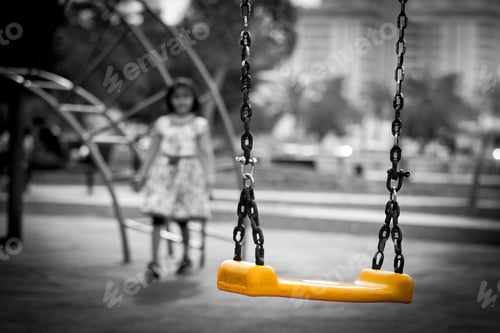 Preview: Girl approaching yellow swings at the children’s playground