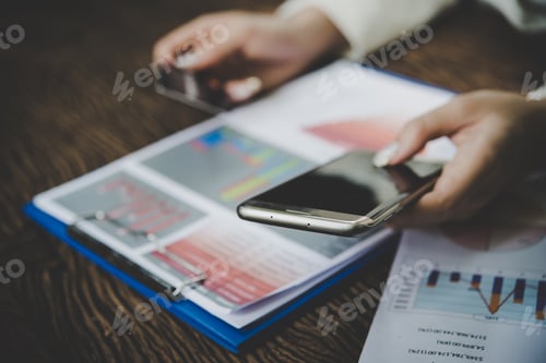 Preview: Woman holding credit card and using smart phone for online shopping with vintage tone.