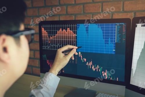 Preview: Young businessman working at stock market with computer screen at office desk.
