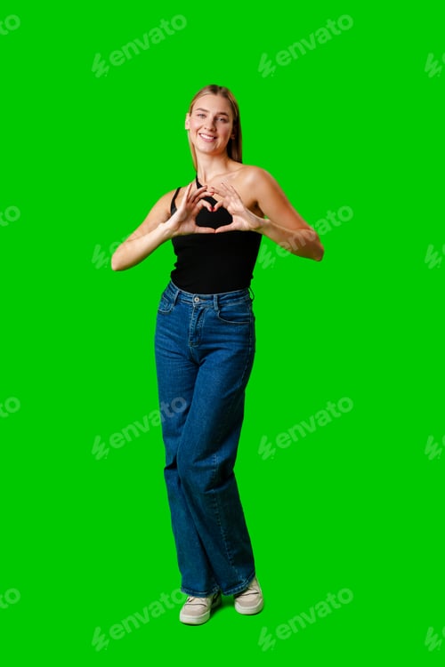 Preview: Young Woman Making Heart With Hands on green background