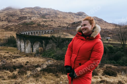 Preview: Tourist enjoying scenic views at the famous viaduct in Scotland during a cool afternoon