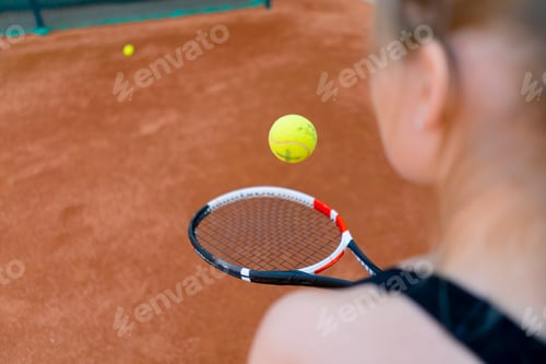 Preview: young girl beginner tennis player hits the ball with a racket on the court trains and learns to hit