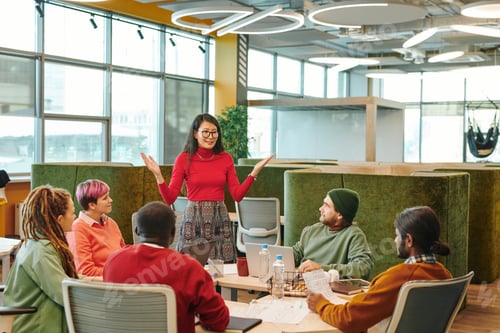 Preview: Medium group of young intercultural designers looking at African businessman