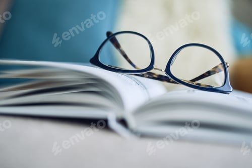 Preview: Reading Glasses Rest on an Open Book