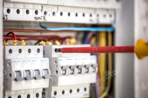 Preview: Man, an electrical technician working in a switchboard with fuses.