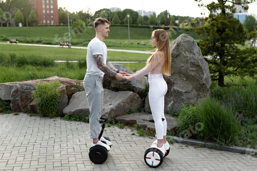 Preview: Young man and woman riding on the hoverboard in the park