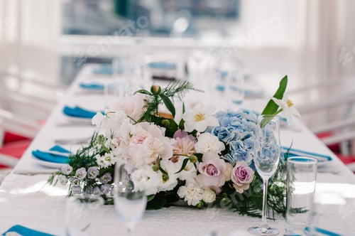 Preview: A composition of flowers and greenery is on a festive table at the wedding party. Close up.