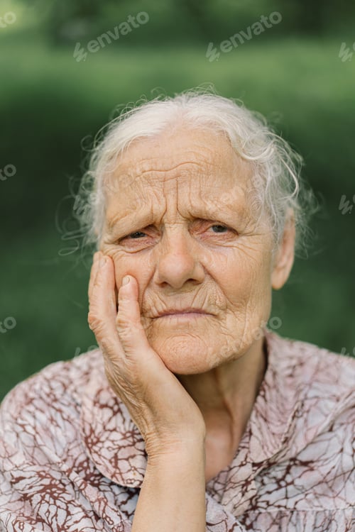 Preview: Portrait of a gray-haired adult grandmother against the background of nature