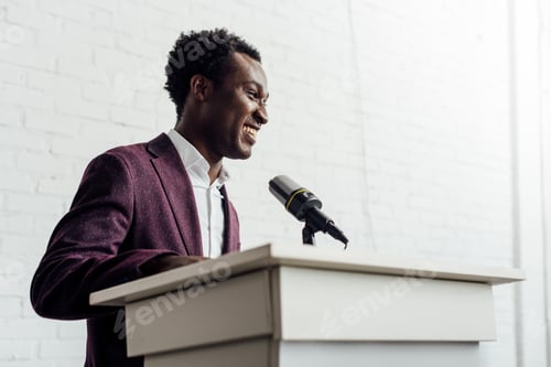 Preview: african american businessman in formal wear smiling during conference