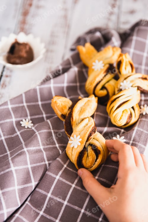 Preview: Kids hand taking delicious Palmiers with chocolate on wooden background