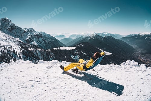 Preview: Man in snowy Italy Trentino Alps sunbed chair in Pinzolo