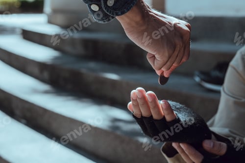 Preview: Young man giving money to homeless beggar man sitting in city.Giving concept.