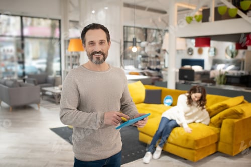 Smiling Man Uses Tablet in Furniture Store