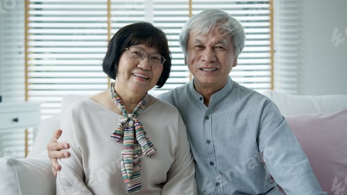 Preview: Portrait of happy senior asian couple relax sitting smile at home indoor on sofa