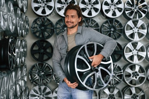 Preview: Many of the disks on walls. Man is in the tire fitting car service