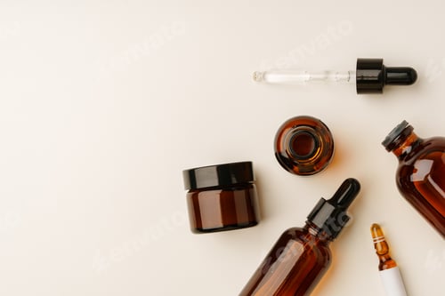Preview: Various Amber Glass Containers for Essential Oils and Skin Care Products Displayed on Light