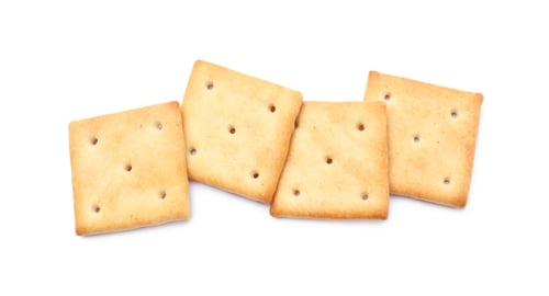 Preview: Tasty crispy square crackers isolated on white, top view