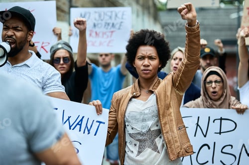 Preview: African American woman with raised fist participating in black civil rights demonstrations.