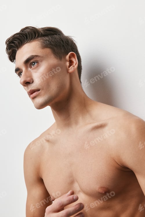 Preview: A man with a naked torso is looking forward on a light background