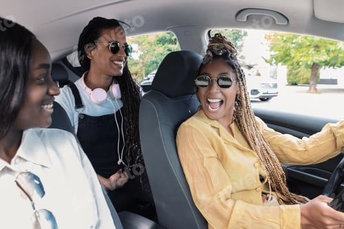 Preview: Happy ethnic female friends riding car on street