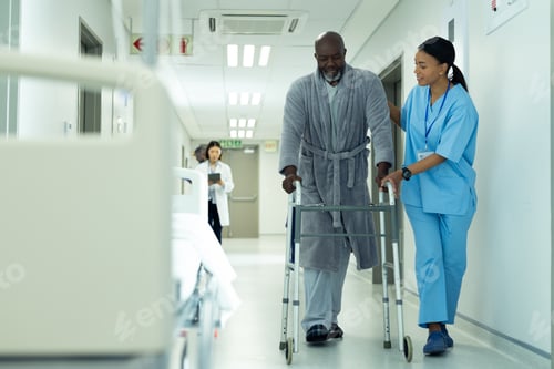 Preview: Diverse female healthcare worker helping senior african american male patient use in hospital