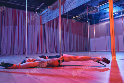 Preview: Sexy female dancer doing the split in pole dance studio