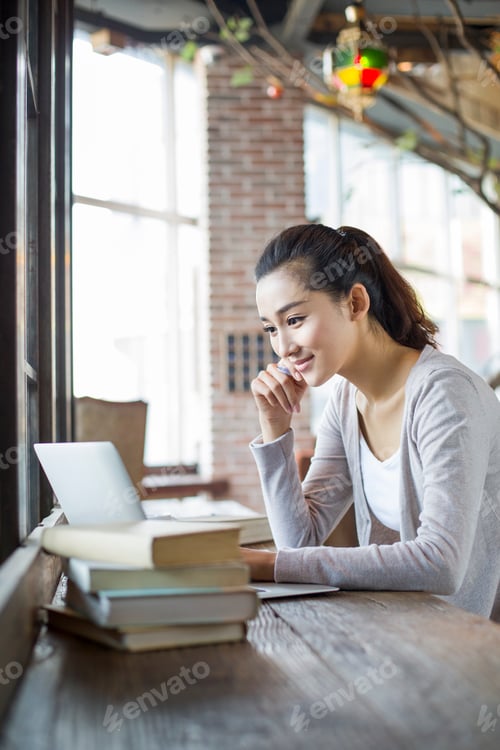 Preview: Young woman studying in cafe